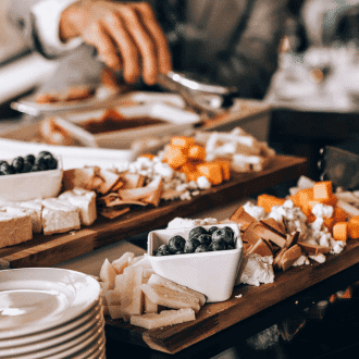 Catered food assortment with hand grabbing with a tongs from tray.